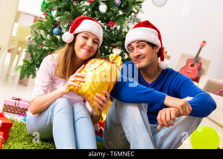 Junges Paar Weihnachten zu Hause feiern. Stockfoto
