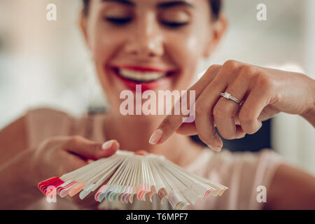 Freudige dunkelhaarige Client mit Ehering und genaue Hände Stockfoto