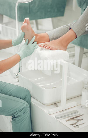 Professionelle beauty Master geben gesund Behandlung Beine von Ihrem Client Stockfoto
