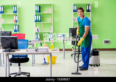 Schöner mann Büro mit Staubsauger reinigen Stockfoto