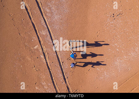 Luftaufnahme echten Menschen spielen mit seinem Schatten während der Sunrise in der Atacama Wüste. Super strukturierte lange Schatten auf einer trockenen Lustig scenic Stockfoto