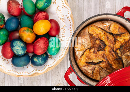 Traditionelle Artisan Brot in Backform und Ostern bemalte Eier. Stockfoto