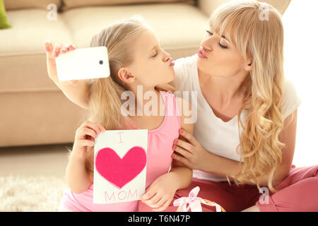 Süße kleine Mädchen und ihre Mutter unter selfie mit handgefertigten Karte zuhause Stockfoto
