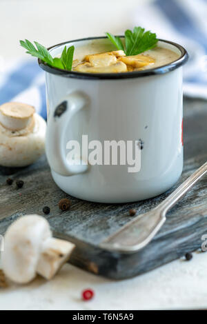 Creme - Suppe mit Champignons in einem Emaille Tasse. Stockfoto
