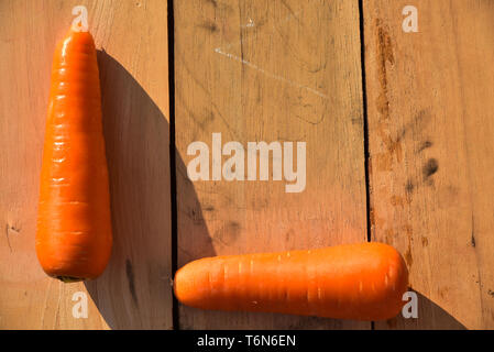 Frische Karotten mit Blatt auf Holzboden Stockfoto