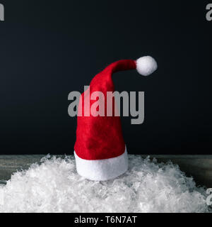 Rote Weihnachtsmann Mütze mit schwarzem Hintergrund Stockfoto