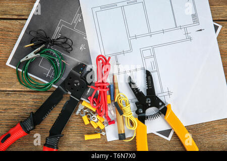 Flach Komposition mit elektrische Werkzeuge und Haus Pläne auf hölzernen Hintergrund Stockfoto