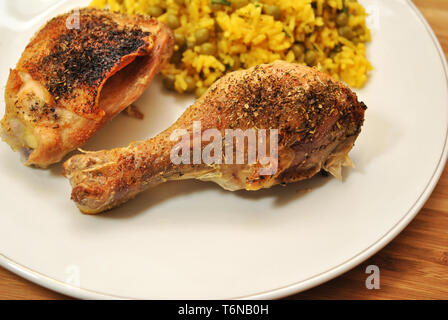 Knusprig gebackenes Huhn serviert mit Reis und Erbsen Stockfoto