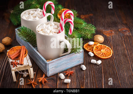 Zwei Tassen mit kleinen Marshmallows auf einem dunklen Hintergrund Stockfoto