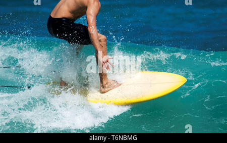 Ein Mann das Surfen auf eine kleine Welle im schönen Tropen Wasser Stockfoto