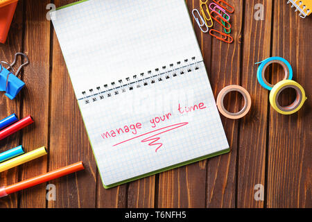 Notebook mit Phrase VERWALTEN SIE IHRE ZEIT auf hölzernen Tisch Stockfoto