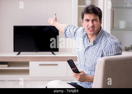 Mann, der versucht, defekte Fernseher zu reparieren Stockfoto