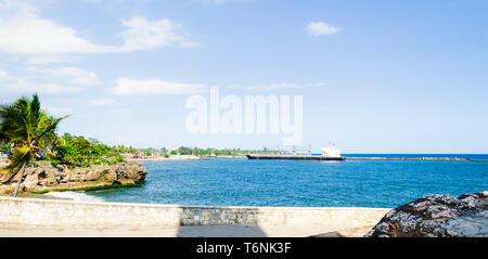 Cargo Boot anreisen, am Eingang zum Hafen von Santo Domingo, Dominikanische Republik mit einem tropischen blauen Meer und klaren und warmen Himmel Stockfoto