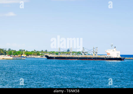 Cargo Boot anreisen, am Eingang zum Hafen von Santo Domingo, Dominikanische Republik mit einem tropischen blauen Meer und klaren und warmen Himmel Stockfoto