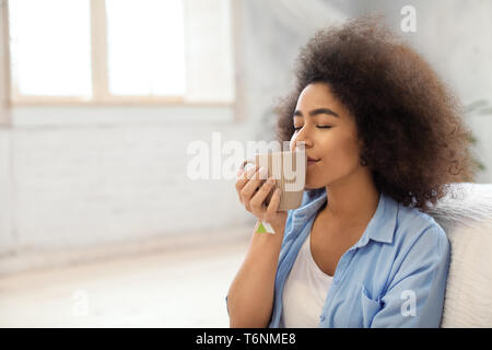 Schöne afroamerikanischen Frau trinkt Tee zu Hause. Stockfoto