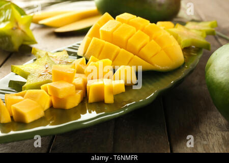 Mit Stücken von frischen Mangos und sternfrucht auf Holztisch, closeup Platte Stockfoto