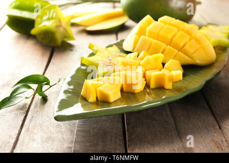 Mit Stücken von frischen Mangos und sternfrucht auf hölzernen Tischplatte Stockfoto