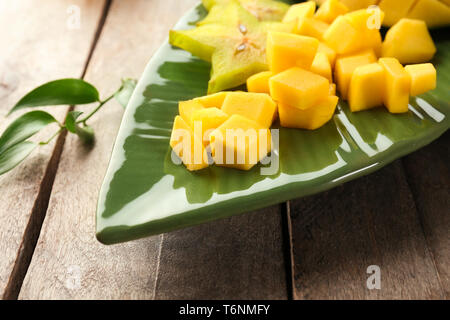 Mit Stücken von frischen Mangos und sternfrucht auf Holztisch, closeup Platte Stockfoto