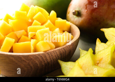 Hölzerne Schüssel mit frischer Mango auf den Tisch, Nahaufnahme Stockfoto