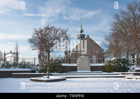 Alte niederländische Kirche mit Friedhof im Winter Stockfoto