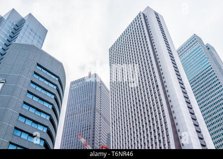 Shinjuku, Tokyo Stadtbild mit niedrigen Winkel Blick auf Modernes Glas Büro hochhaus Hochhaus Apartment Gebäude und bewölkter Himmel Stockfoto