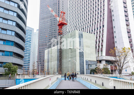 Tokyo, Japan - 30. März 2019: Shinjuku Stadtbild mit erhöhten Laufsteg und Modernes Glas Büro hochhaus Hochhaus Apartment Gebäude c Stockfoto