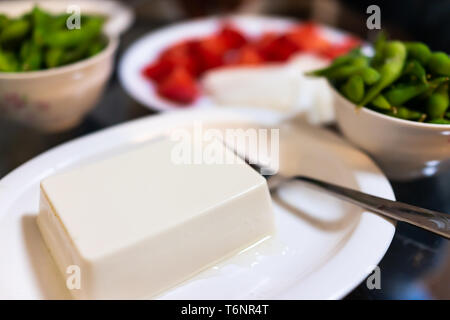 Platte von gekochten und kalten Tofu im Restaurant oder Haus mit Gemüse snack gekochte Edamame und Gabel Stockfoto