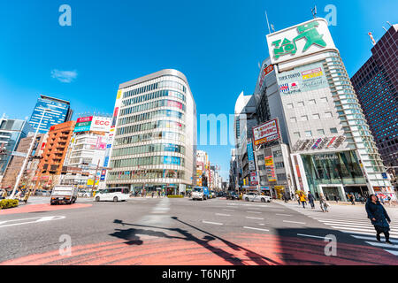 Tokyo, Japan - 1. April 2019: Shinjuku Kreuzung Stadtbild mit Menschen überqueren die Straße in der morgendlichen Fahrt zur Arbeit auf der Straße und der bunten Gebäude Stadtbild Stockfoto