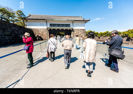 Tokio, Japan - April 1, 2019: Park mit Menschen zu Fuß betreten Tor zu Imperial Palace während der Frühling in der Innenstadt Stockfoto