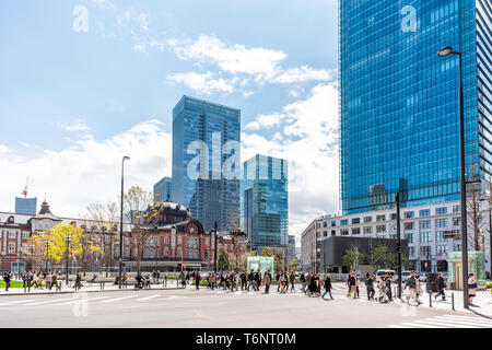 Tokio, Japan - 1. April 2019: Blick auf das Hauptbahnhof-Gebäude in der Innenstadt mit Menschen, die die Straße durch Wolkenkratzer überqueren Stockfoto