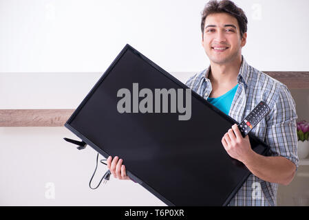 Mann, der versucht, defekte Fernseher zu reparieren Stockfoto