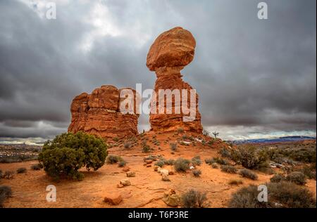 Felsformation Balanced Rock, dunkle bewölkter Himmel, Arches National Park, in der Nähe von Moab, Utah, USA Stockfoto