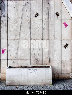 Rosa & Schwarz lackiert Käfer auf eine Wand. Street Art und leeren Blumentopf Stockfoto