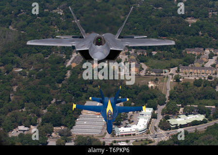 Us Air Force Maj. Paul "Loco" Lopez, F-22 Demo Team Commander/Pilot, fliegt über die US Navy Blue Angels während eines legendären Formation, in Beaufort, South Carolina, 25. April 2019. Diese Stunde langen historischen Flug empfohlene Zwei von Premier Antenne demonstration Teams der Welt. (U.S. Air Force Foto von 2 Leutnant Samuel Eckholm) Stockfoto