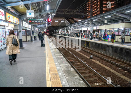 Osaka, Japan - 28. Feb. 2018: Fluggäste wartete der Zug auf Sakaihigashi Bahnsteig in der Nacht. Stockfoto