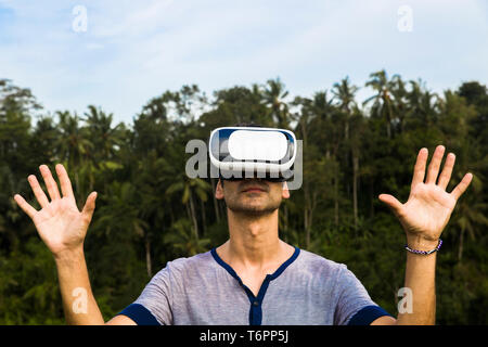 Junger Mann mit VR-Brille in der tropicalforest Stockfoto