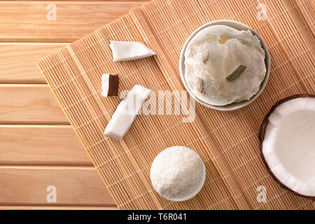 Coconut Eisbecher mit Kokosnuss auf einem hölzernen Tisch gefüttert eingerichtet. Horizontale Komposition. Ansicht von oben. Stockfoto