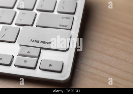 Computer Tastatur mit Phrase gefälschte Nachrichten auf hölzernen Tisch Stockfoto