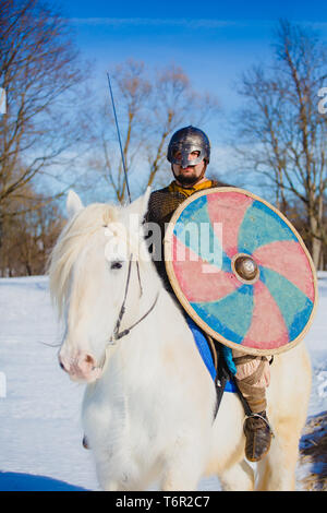 Mann in Anzug der alten Wikinger reiten Big White Horse Stockfoto