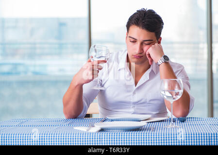 Schöner Mann alleine im Restaurant am Datum Stockfoto