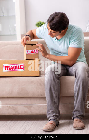 Mann öffnen zerbrechliches Paket aus dem Internet bestellt Stockfoto