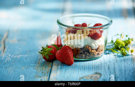 Ein frisches, gesundes Joghurt, Erdbeere und Müsli smoothie Schüssel Frühstück auf einem urigen Tabelle einstellen. Stockfoto