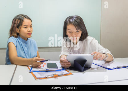 Junge asiatische Büro Mitarbeiter auf Tablet Stockfoto