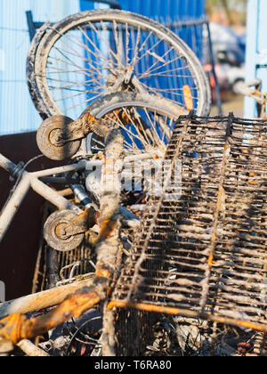 Rostiges Metall junk Objekte Fahrrad, Warenkorb vom Meer zu einem industriellen Quay/Cargo port Bereich gesammelt. Stockfoto