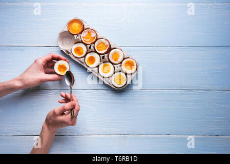 Gekochte Eier in den Händen auf einem hölzernen Hintergrund Stockfoto