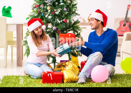 Junges Paar Weihnachten zu Hause feiern. Stockfoto