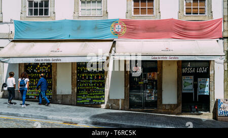 Porto, Portugal - 29. April 2019: Antique Shop der berühmten Getränke im Zentrum von Porto, Portugal mit portugiesischer Flagge ausserhalb drapiert Stockfoto