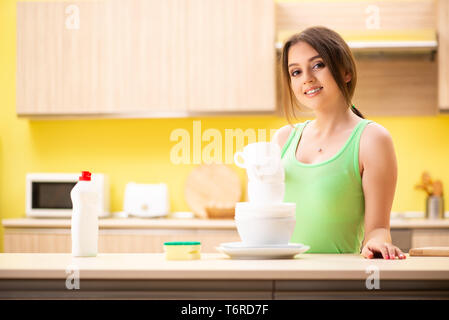 Junge Frau Reinigung und Abwasch in der Küche Stockfoto