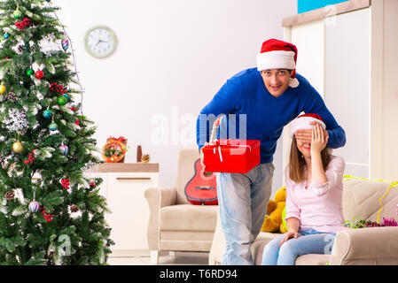 Junges Paar Weihnachten zu Hause feiern. Stockfoto