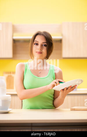 Junge Frau Reinigung und Abwasch in der Küche Stockfoto
